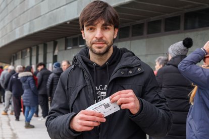 Un joven aficionado muestra su entrada para el partido.