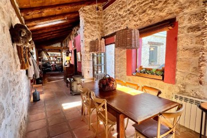 El comedor destaca por sus paredes de piedra original y una decoración cálida de inspiración rural