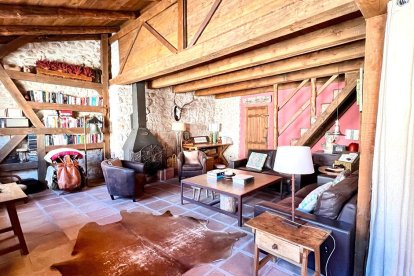 El salón principal mantiene el estilo rústico con vigas de madera, chimenea y mobiliario tradicional