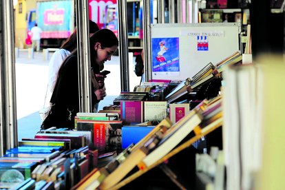 Una lectora busca su libro en la feria.