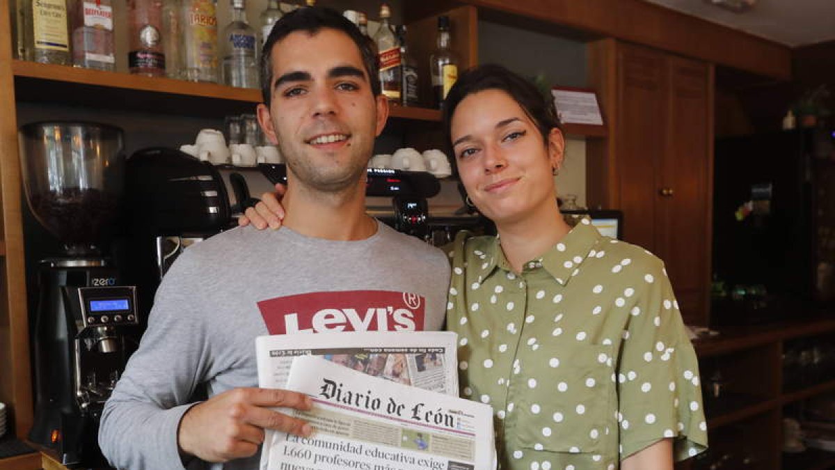 Isaac y Grisela posan con el Diario de León en el interior de la Cafetería Mittaca, un lugar donde nunca falta este periódico. MARCIANO PÉREZ