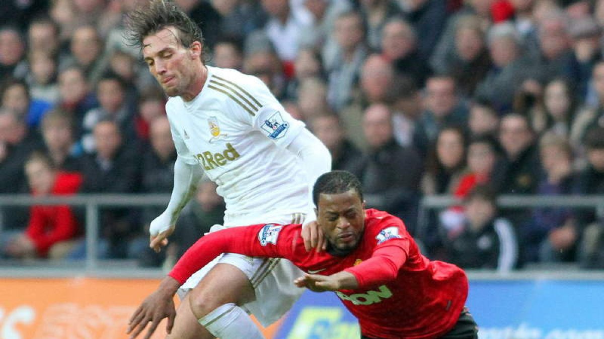 Michu, a la izquierda, pugna por un balón con el jugador del Manchester Patrice Evra.