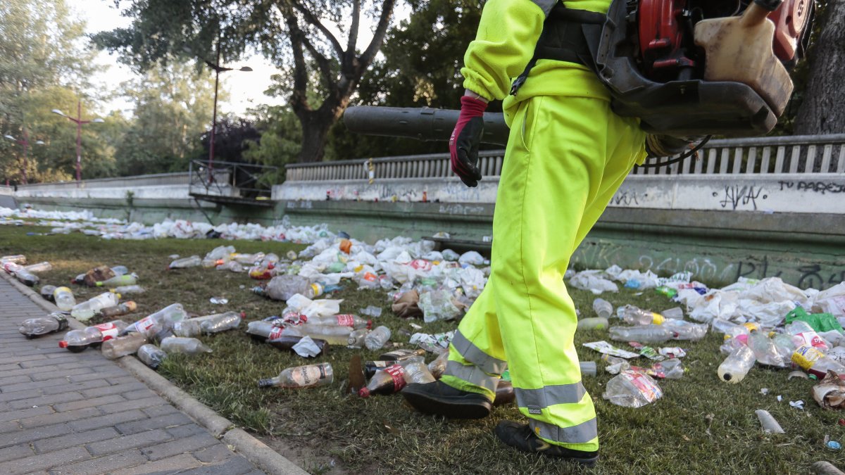 Operarios del servicio de limpieza del Ayuntamiento de León retiran la basura acumulada en la orilla del Río Bernesga de la capital leonesa tras la noche de San Juan. CAMPILLO