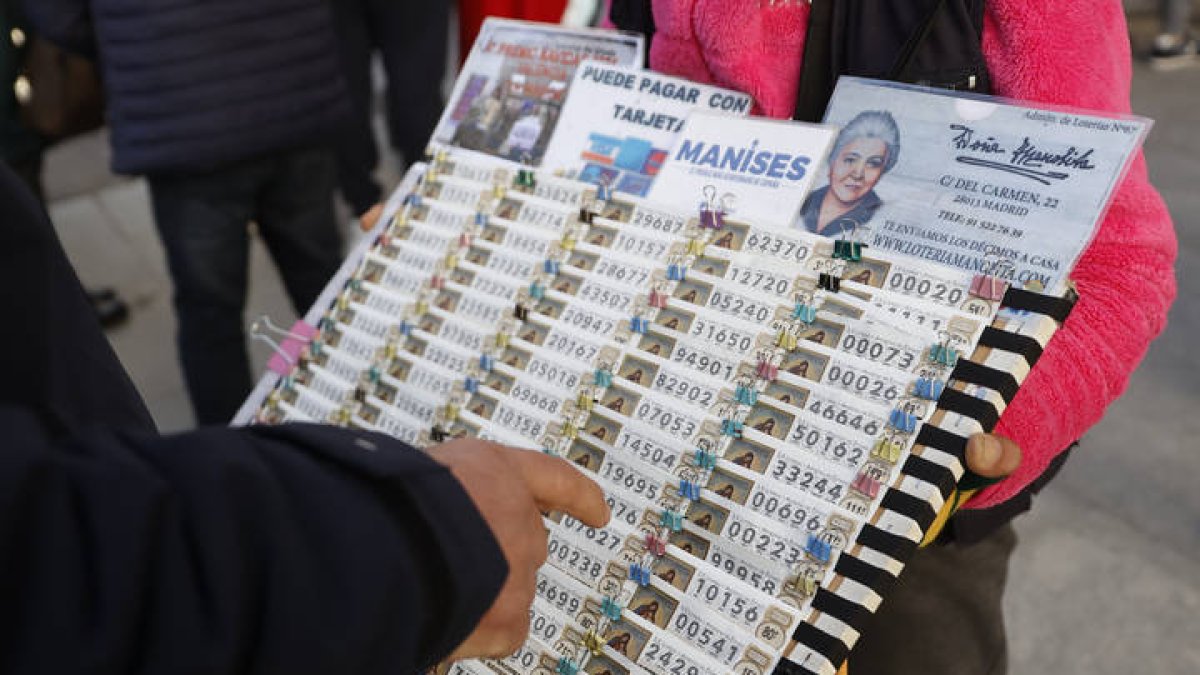 Una lotera vende décimos de Lotería para el sorteo navideño de El Gordo en la Puerta del Sol de Madrid. MARISCAL
