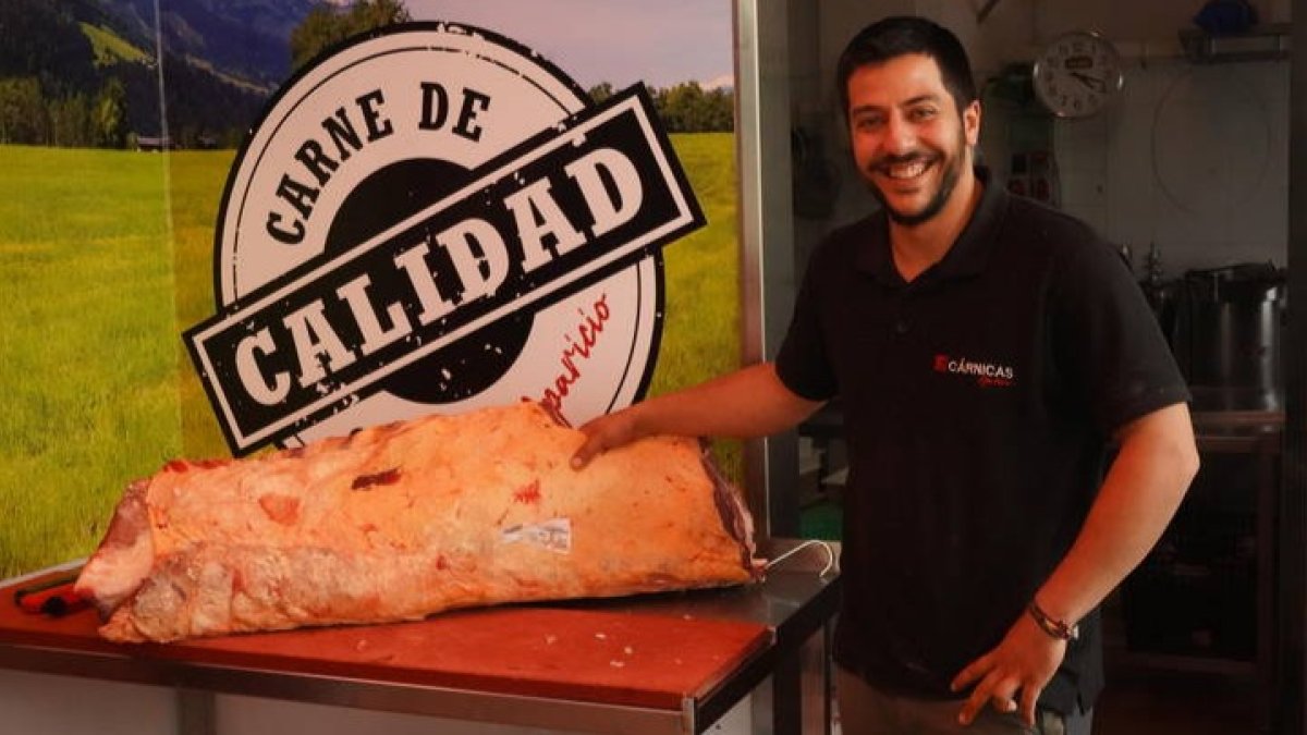 Pablo Aparicio posa con una pieza de carne en su carnicería en Veguellina de Órbigo. J. NOTARIO