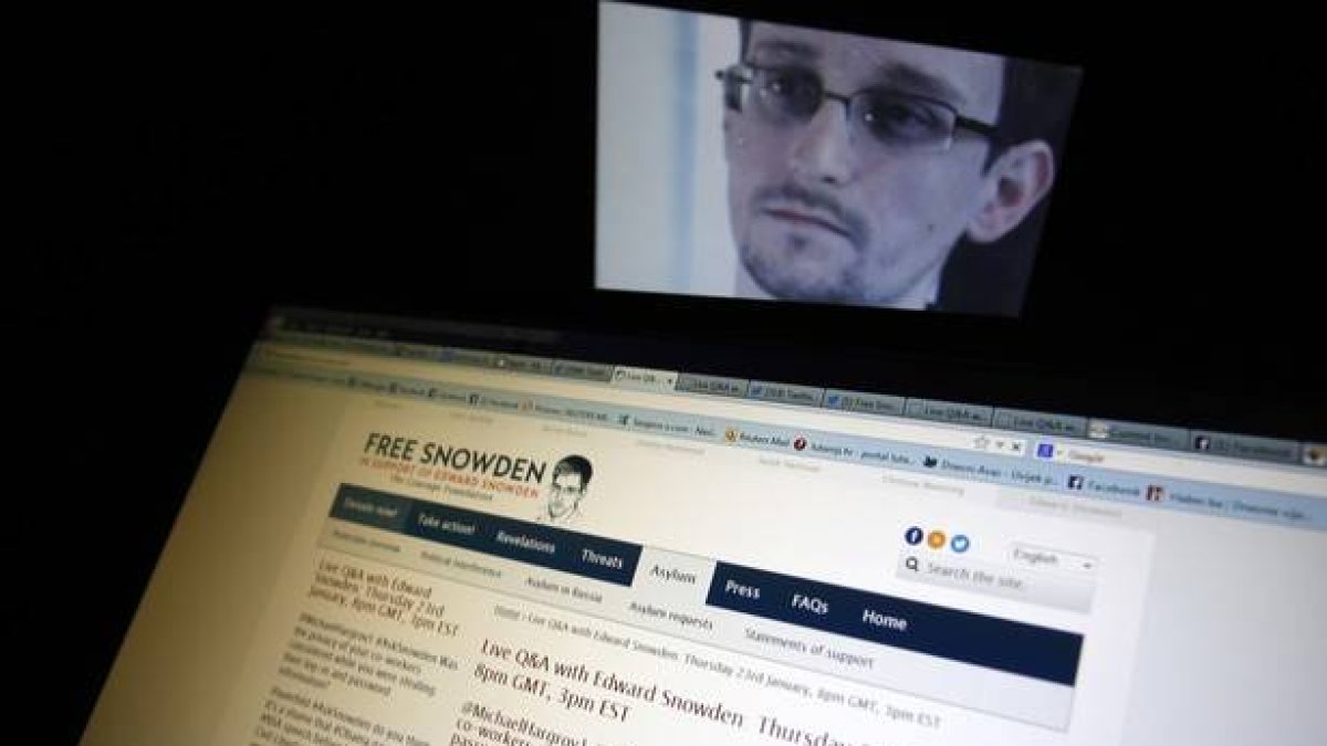 Conversación entre Snowden e internautas con un retrato del exagente de la NSA al fondo.