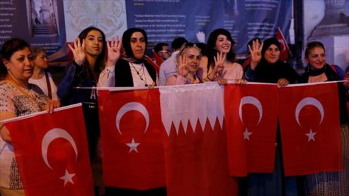 Mujeres con banderas turcas y qatarís en Estambul.