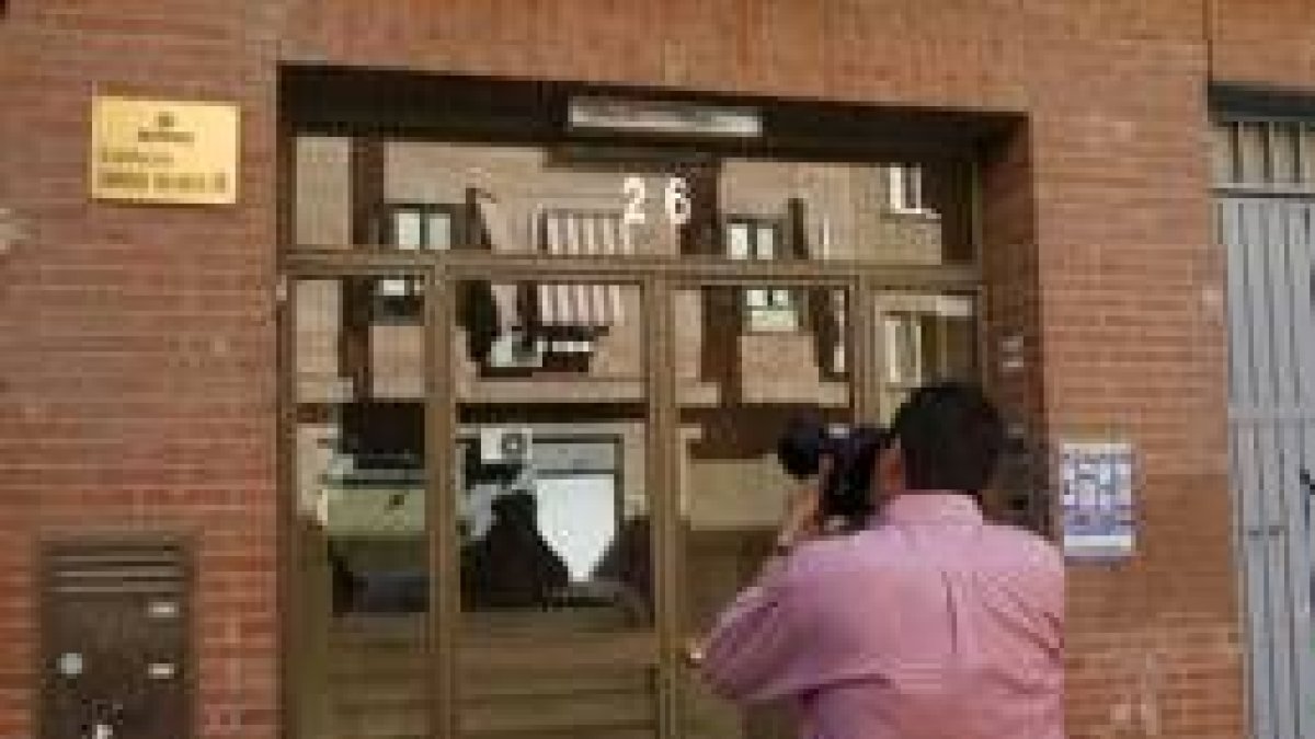 Un reportero gráfico fotografía la puerta de un edificio donde una mujer asesinó ayer a su pareja