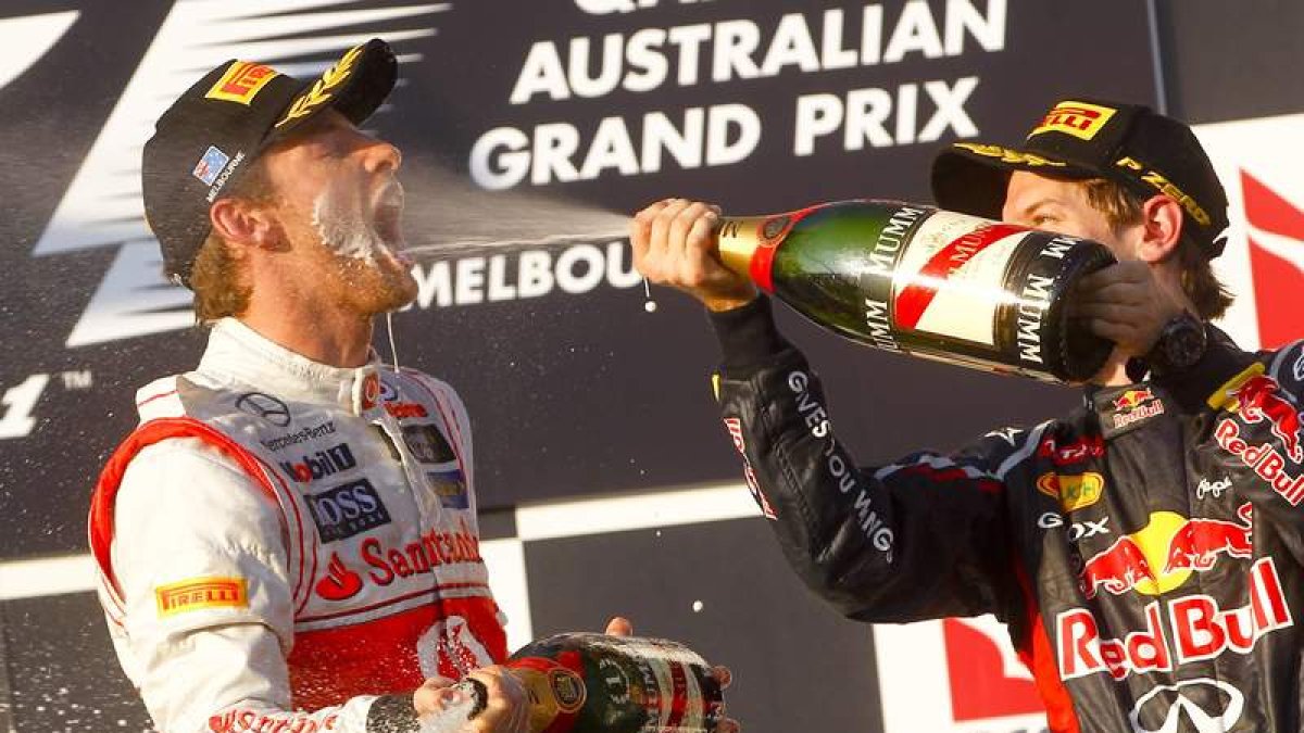 Jenson Button celebra en el podio con el alemán Sebastian Vettel, primer y segundo en Melbourne, su victoria en el Gran Premio de Australia de la Fórmula 1.