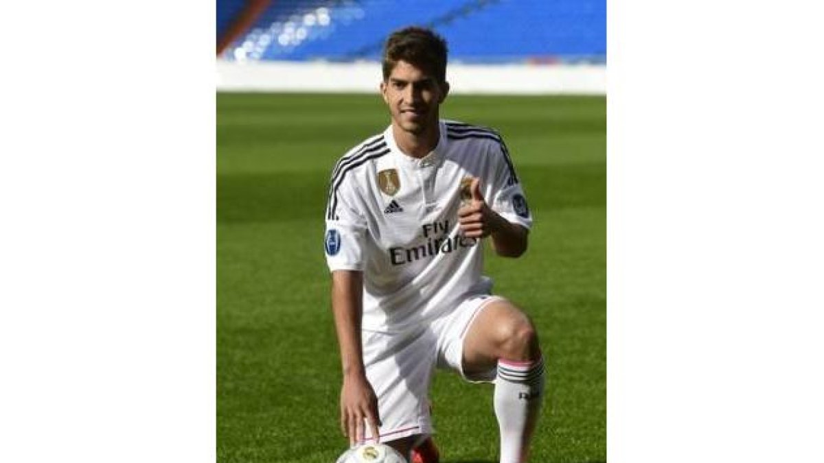 Lucas Silva posa vestido de blanco sobre el césped del Santiago Bernabéu, tras ser presentado como nuevo jugador del Madrid.