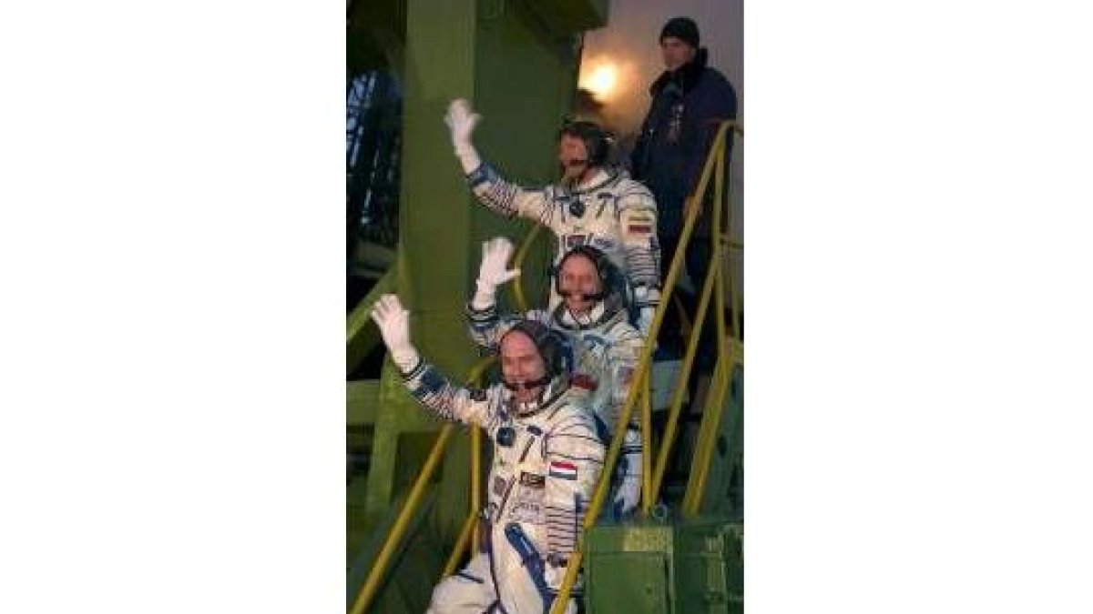 Los tres astronautas que partieron ayer se despiden antes de introducirse en la «Soyuz»