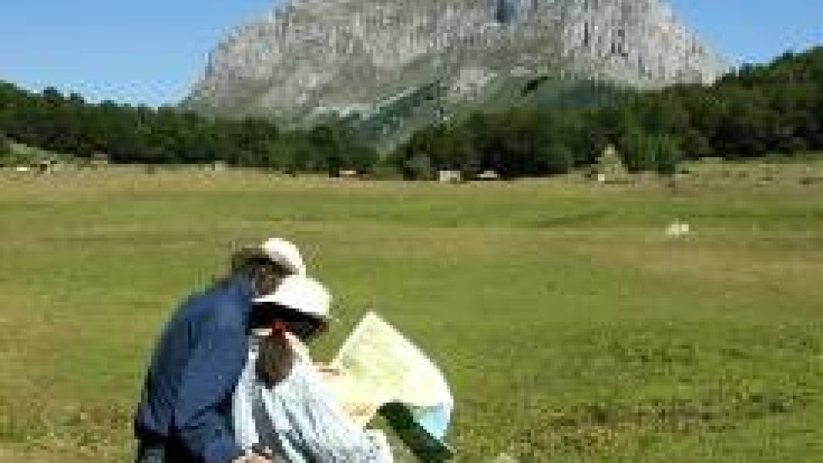 Dos turistas consultan un mapa antes de iniciar una excursión en el valle de Sajambre