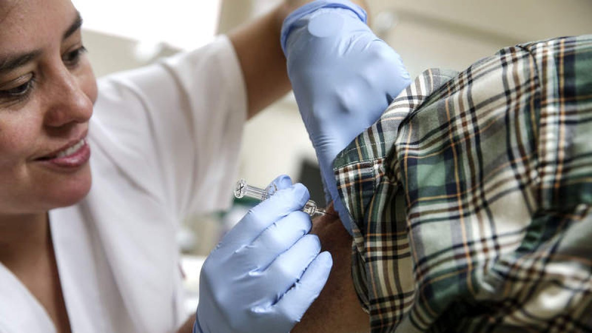 Una enfermera pone una dosis de vacuna contra la gripe en un centro de salud. MANUEL BRUQUE