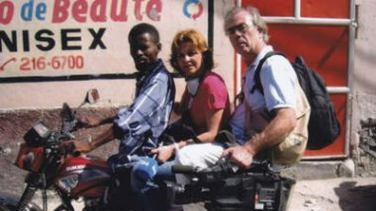 Manolo Ovalle con su cámara, su compañera Almudena Ariza y el motorista que les transportaba.