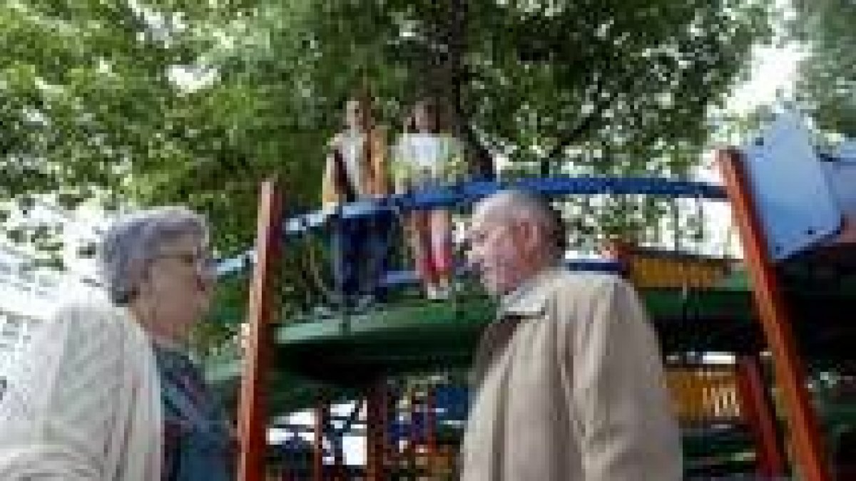 Dos abuelos que se encuentran haciendo de canguros de sus nietos en uno de los parques españoles