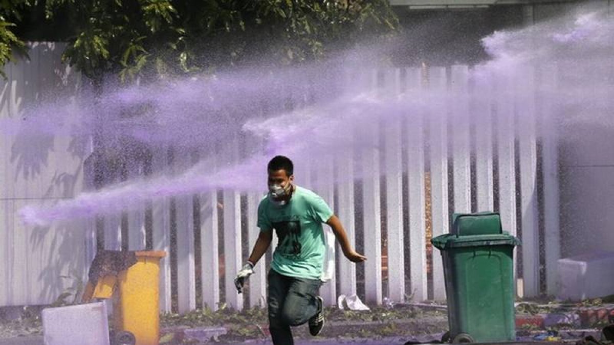 Varios manifestantes se enfrentan a la policía durante una marcha de protesta con la intención de alcanzar las oficinas de la Comisión Electoral en Bangkok (Tailandia).