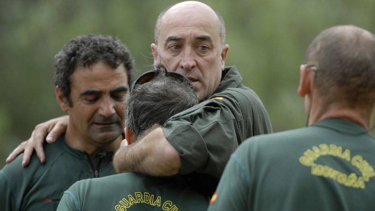 Compañeros de los tres guardias civiles que han fallecido hoy al caer su helicóptero cuando llevaban a cabo un rescate en la zona de La Polinosa, en Maraña, se abrazan en el lugar donde se organizó el rescate