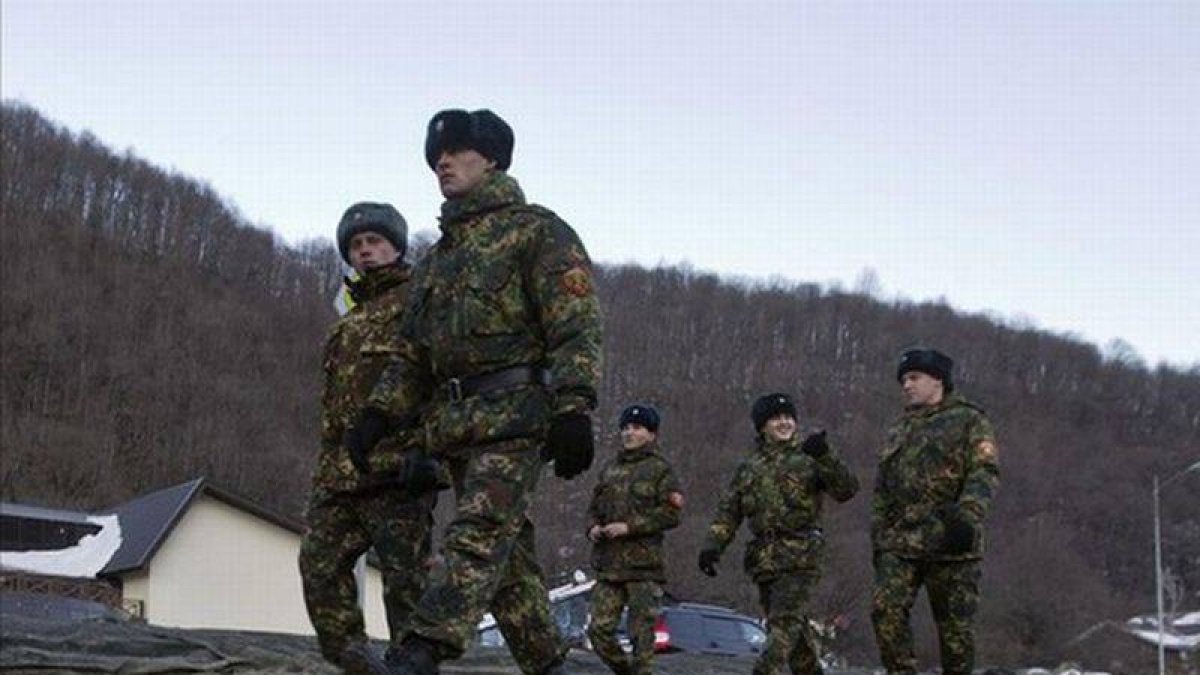 Agentes rusos caminan por una carretera cercana al complejo de Krasnaya Polyana, que acogerá las pruebas de esquí y 'snowboard', el día 4.