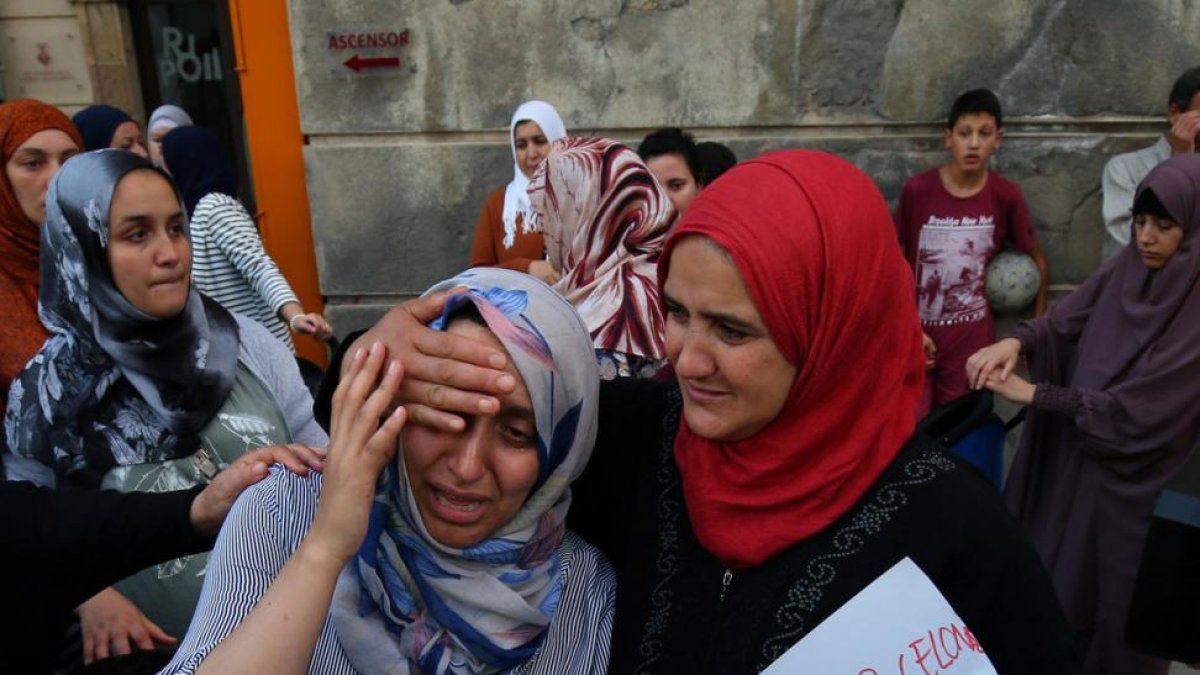 La hermana de Moussa y Driss Oukabir (izquierda) llora desconsolada en un acto contra el terrorismo, en Ripoll.