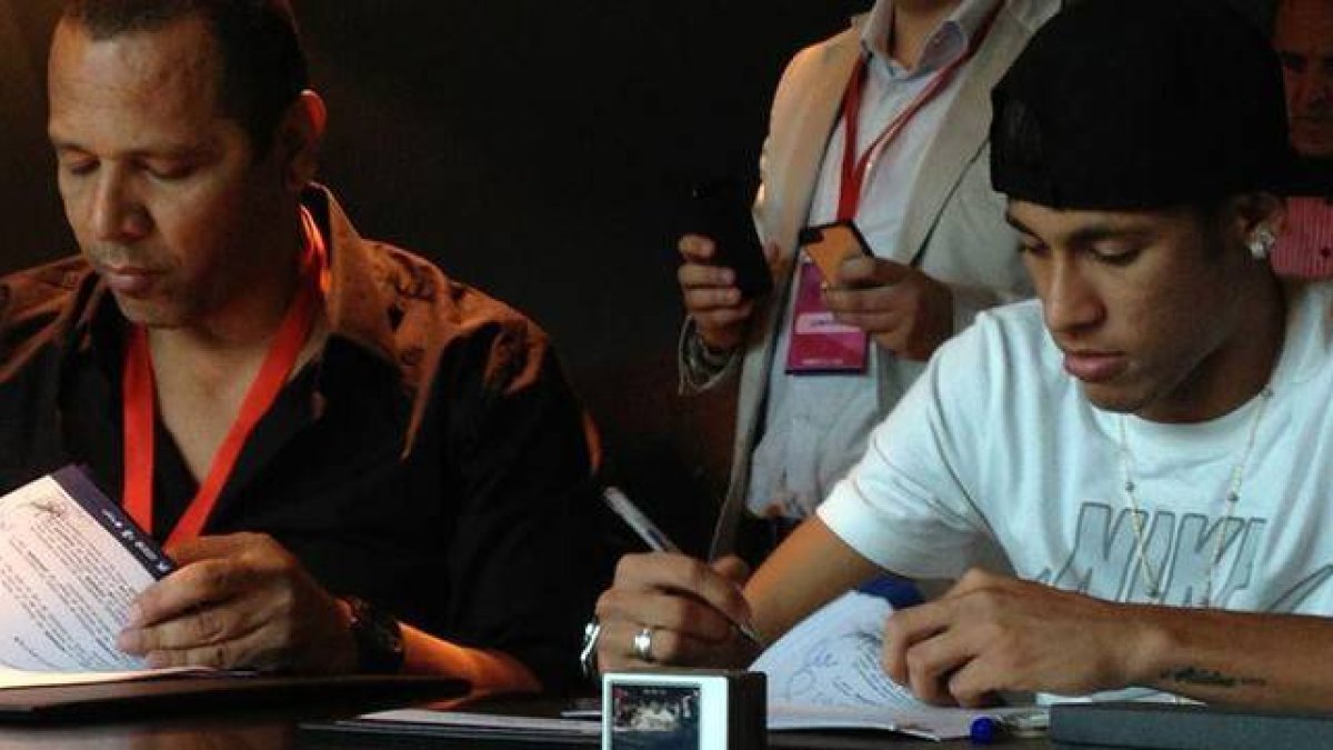Neymar y su padre, durante la firma del contrato del delantero brasileño como jugador del Barça, el 3 de junio del 2013.