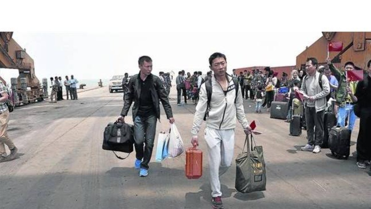Ciudadanos chinos se preparan para embarcar en una fragata de la Armada china en Al Hudayda (Yemen).