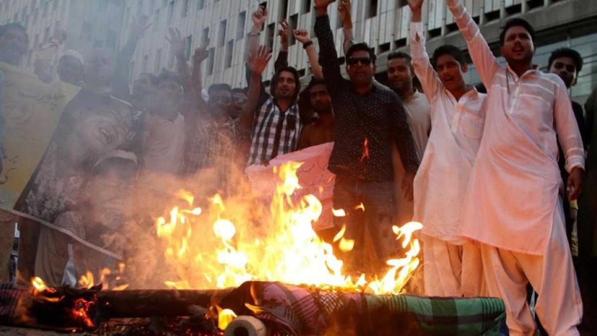 Manifestantes queman una imagen de la líder de facto de Birmania, Aung San Suu Kyi, durante una protesta contra la persecución de los rohinyas, en Karachi (Pakistán), el 17 de septiembre.
