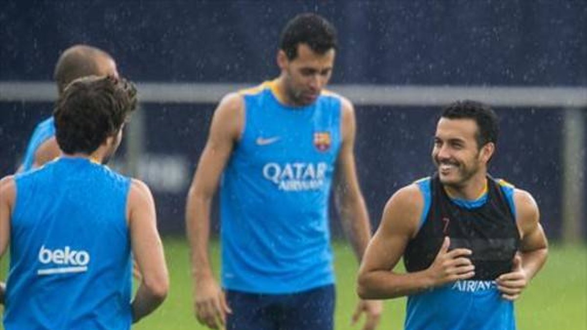 Pedro bromea con Sergi Roberto, ante Busquets y Mascherano, ayer.