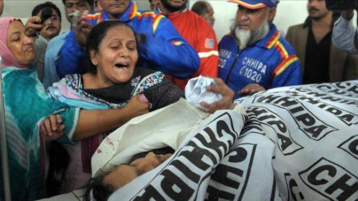 La madre de uno de los vacunadores asesinados llora desesperada junto al cadáver de su hijo, en la morgue de un hospital de Karachi.