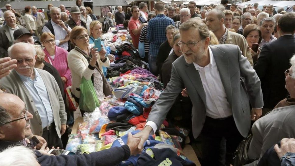 El líder del PP, Mariano Rajoy, durante un paseo electoral este lunes en Santa Comba (A Coruña), en apoyo de la candidatura de Alberto Nuñez Feijóo.