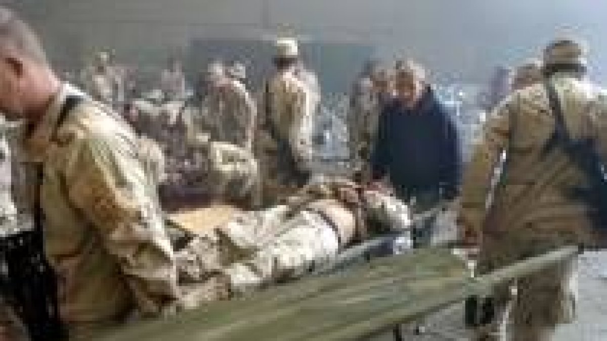 Soldados americanos evacúan a un herido en el comedor de la base militar de Mosul