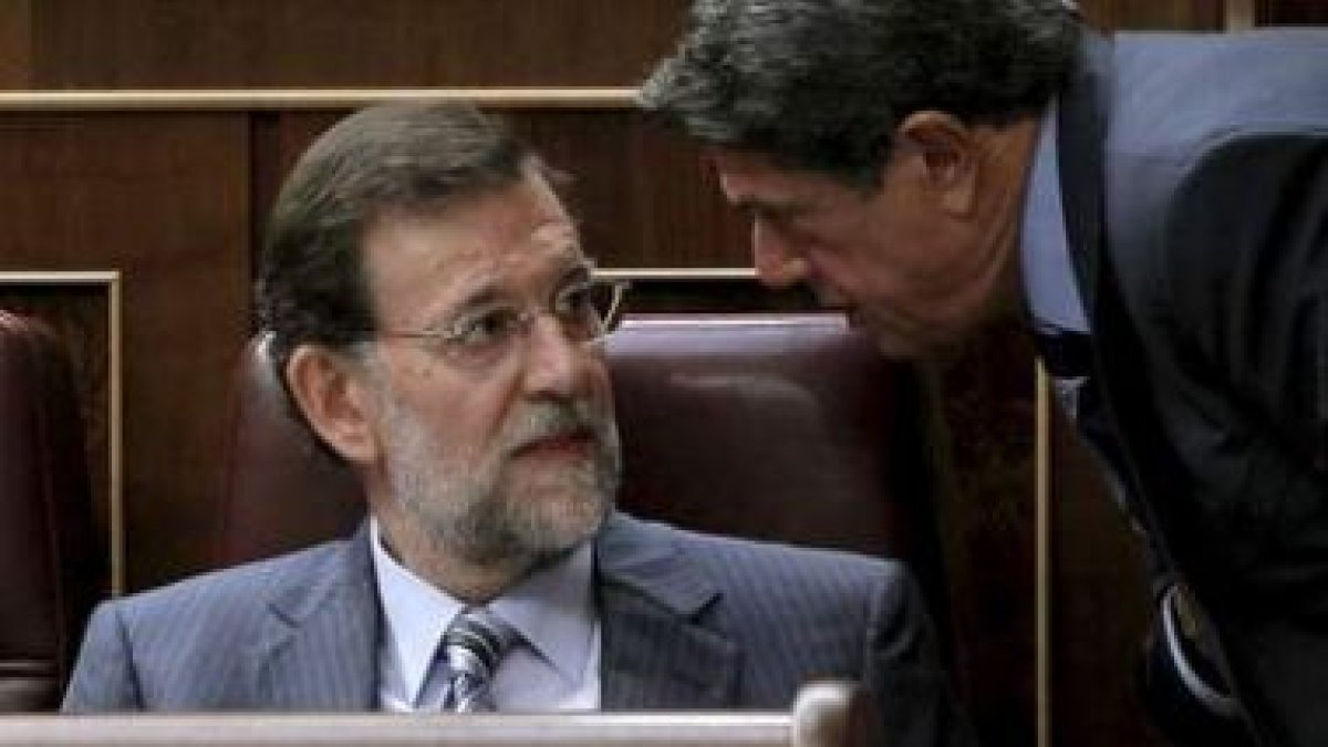 Rajoy conversa con Federico Trillo durante la sesión de control al Gobierno.