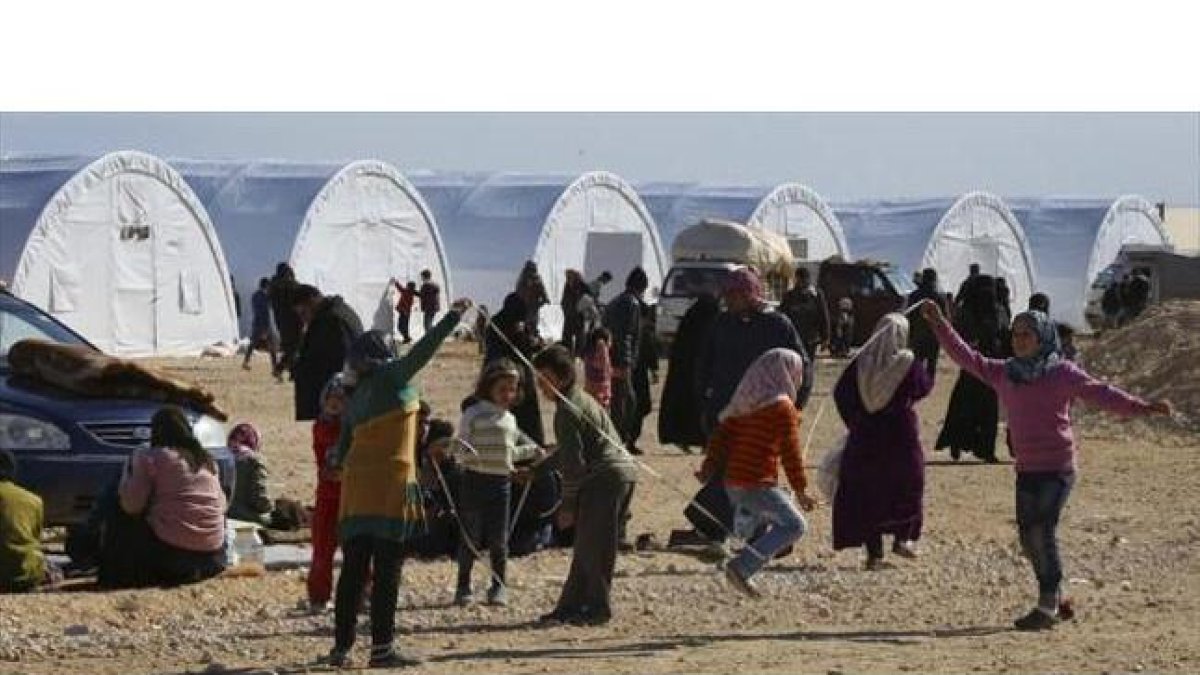 Niños sirios juegan en un campamento temporal para refugiados.