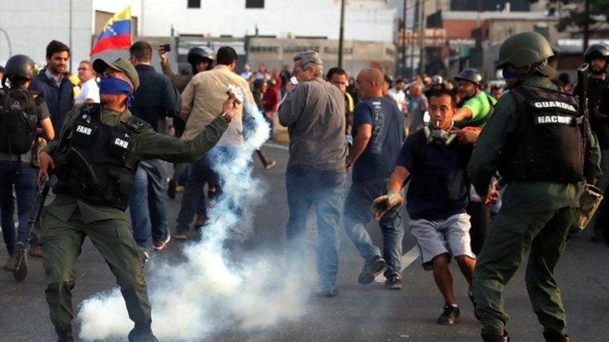 Un militar lanza un bote de gas lacrimógeno durante los disturbios en Caracas