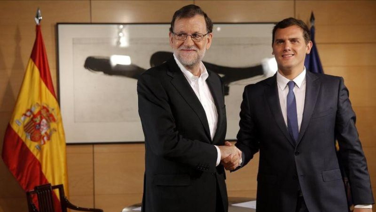 Rajoy y Rivera se saludan al inicio de una reunión el 10 de agosto en el Congreso.