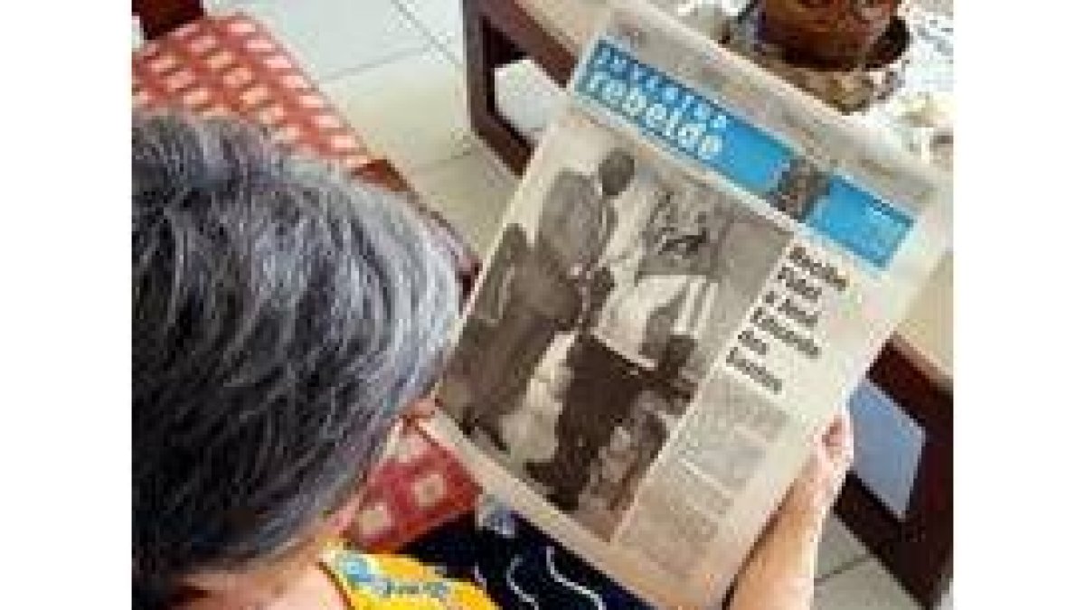 Una mujer lee el diario en el que aparece la foto del encuentro