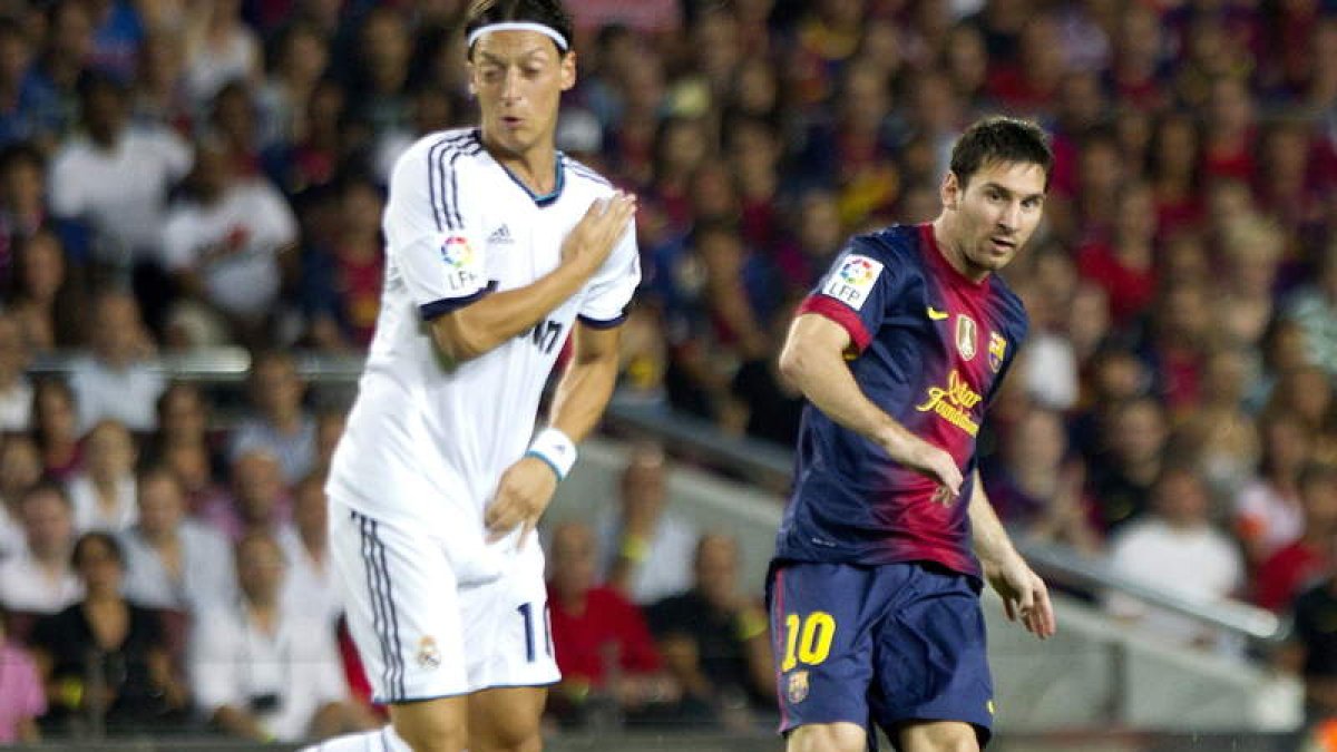 Özil intenta tapar el disparo de Messi en la ida de la Supercopa.
