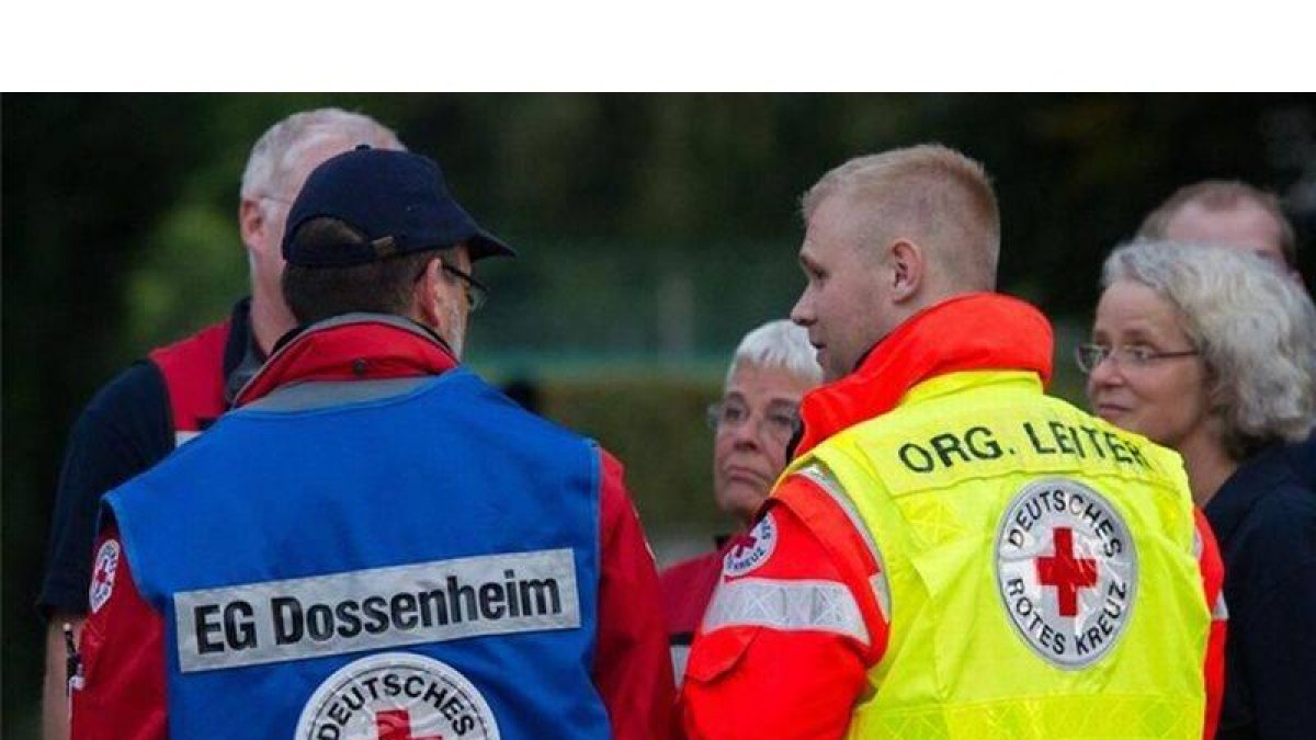 Miembros de la Cruz Roja de Alemania permanecen cerca de la escena del crimen.