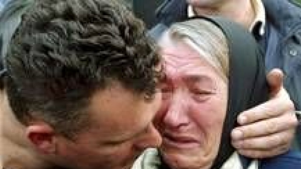 Un serbio consuela a su madre tras los ataques de los albaneses en Kosovo