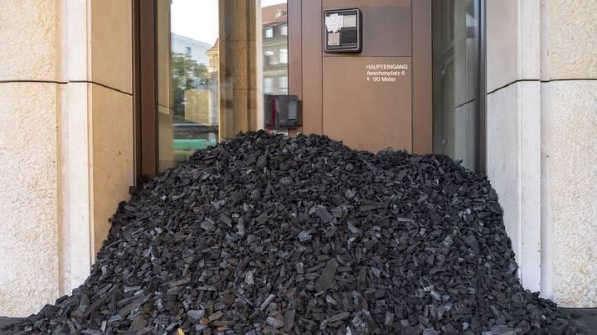 Un grupo de activistas del Colectivo por la Justicia Climática han bloquedado este lunes con carbón la entrada del banco suizo Credit Suisse, en Base, en protesta por el uso de combustibles fósiles.