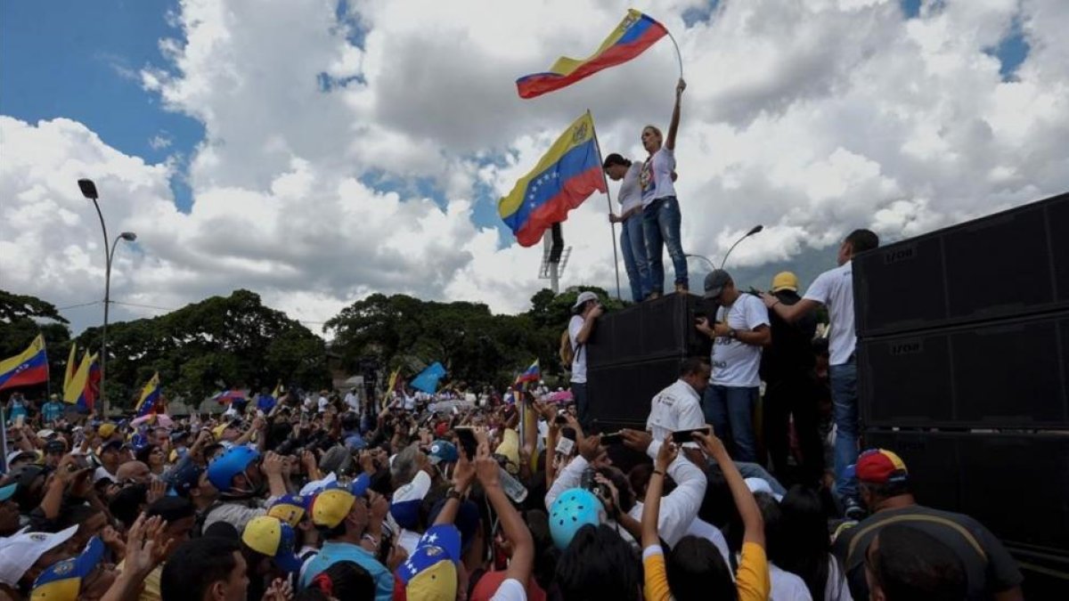 Lilian Tintori, mujer del opositor en prisión Leopoldo López, y la exdiputada María Corina Machado presiden con banderas una prostesta este fin de semana en Caracas.