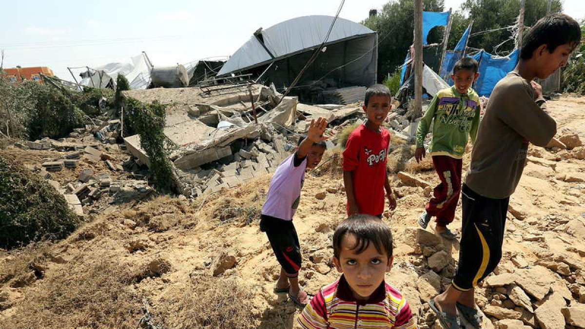 Varios jóvenes palestinos en la zona destruida por los cazas israelíes.