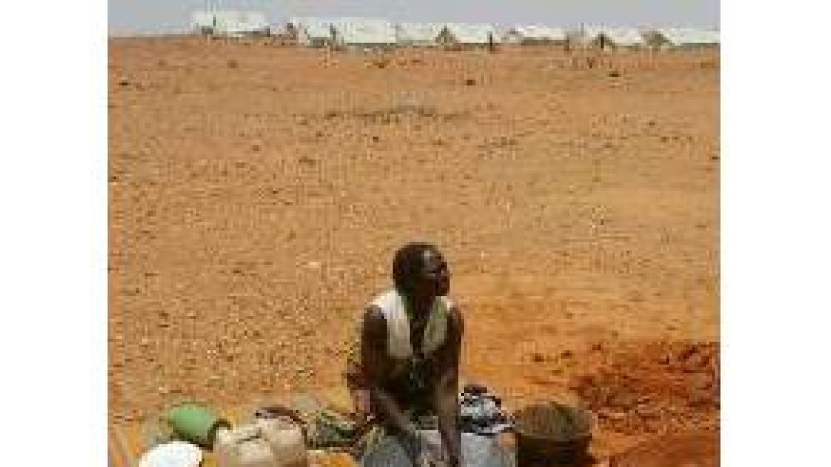 Una sudanesa refugiada lava su ropa   cerca de unas tiendas de campaña en el Chad