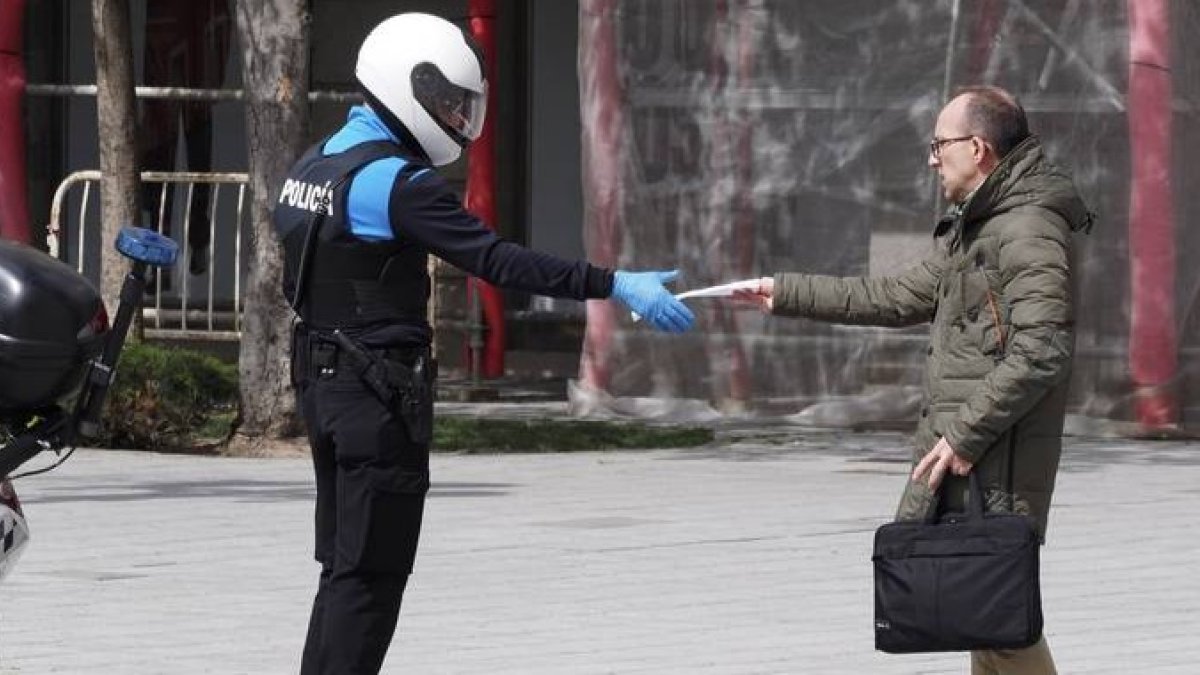 Un policía local solicita documentación a un viandante en la plaza Zorrilla de Valladolid, este martes. R. GARCÍA