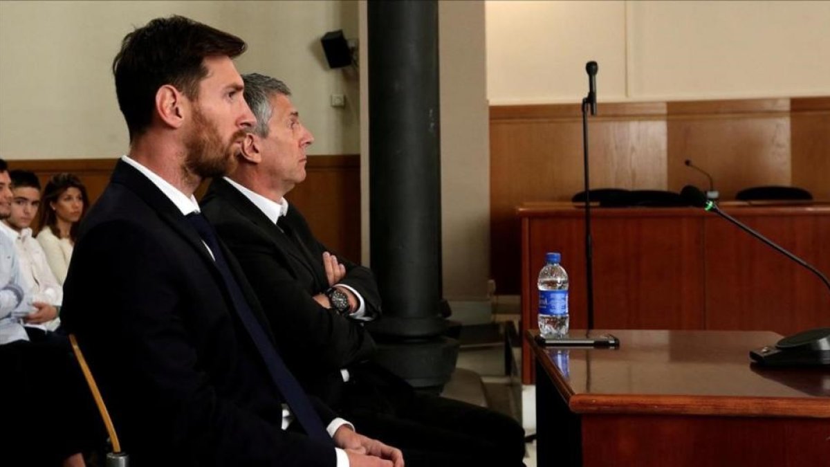 Messi y Jorge, su padre, durante el juicio en Barcelona.