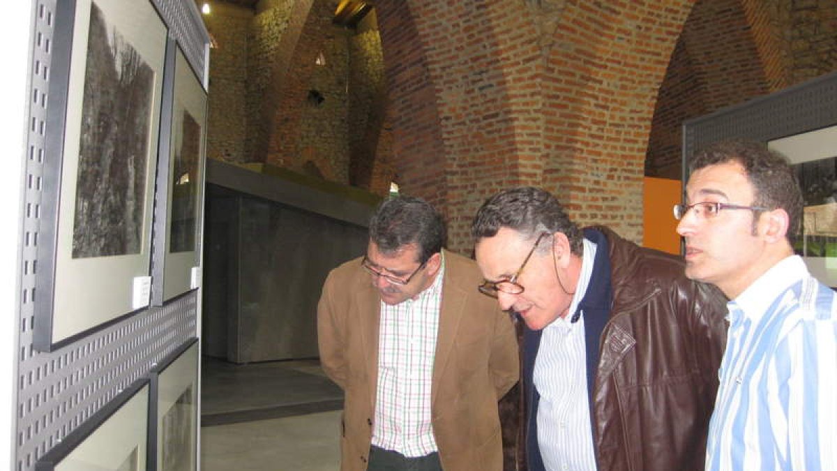 Los alcaldes de Sabero y Bembibre, y el director del museo, contemplan una fotografía.