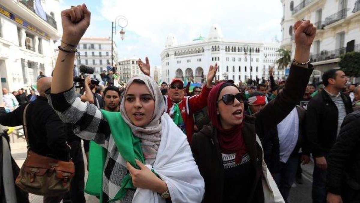 Ciudadanos argelinos gritan consignas y ondean banderas nacionales durante una protesta contra el presidente interino, Abdelkader Bensalah, en Argel.