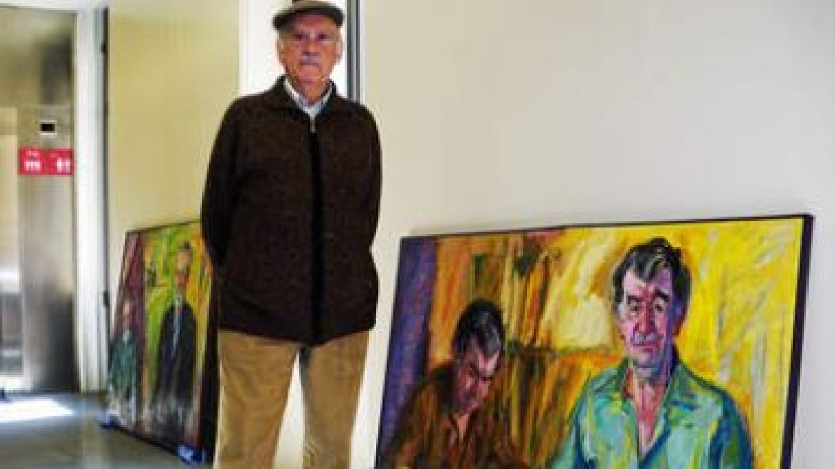 El artista leonés Modesto Llamas Gil posa junto a algunos de los llamativos retratos del poeta y pre