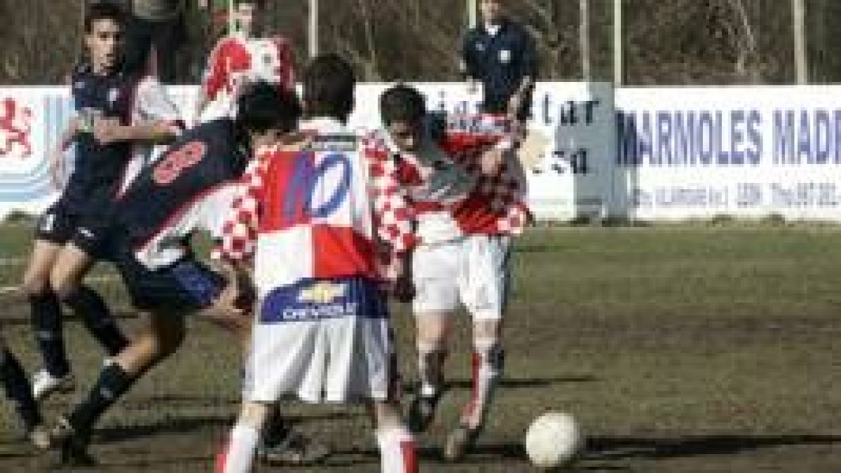 Jugadores de los dos equipos disputan el balón durante el partido