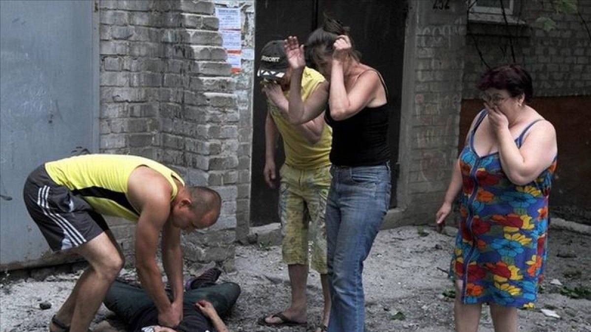 Un hombre intenta reanimar a un herido como consecuencia de los enfrentamientos entre los separatistas pro rusos y tropas ucranianas en Slavyansk ,Ucrania