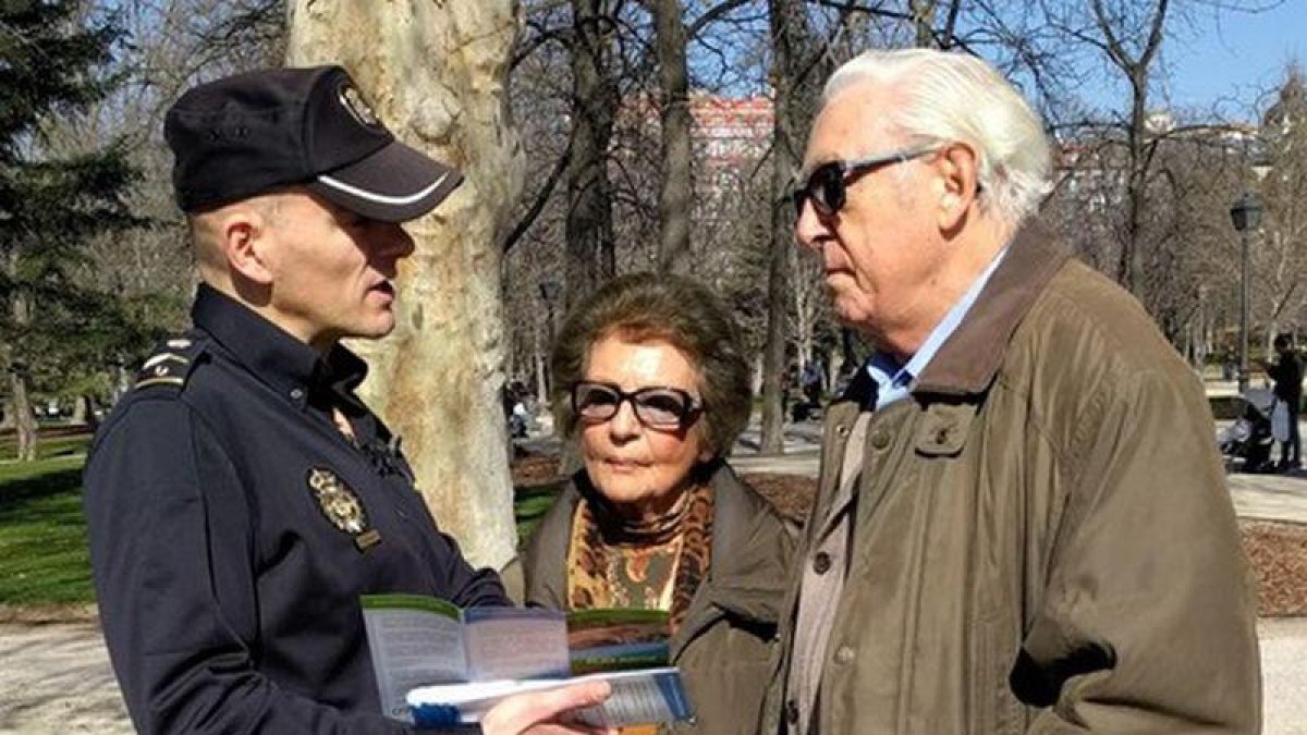 Un policía informa a una pareja de jubilados en una campaña para evitar hurtos.